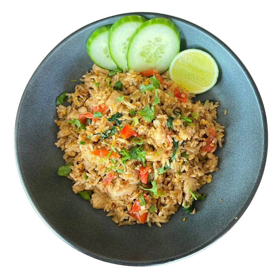 Thai chicken fried rice with egg, tomato and herbs, cucumber and lime on the side